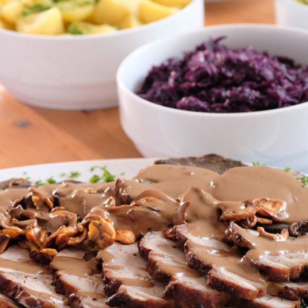 Tafelfertig angerichteter Braten mit Pilzrahmsauce und Beilagen von Partyservice Rode